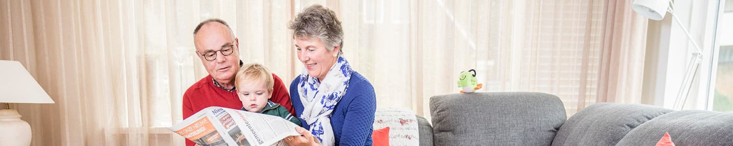 Opa en oma lezen krant met kleinkind